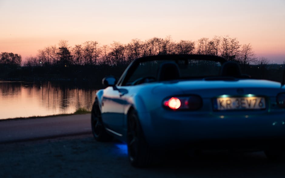 Rear view of a blue car at sunset representing long-term vision