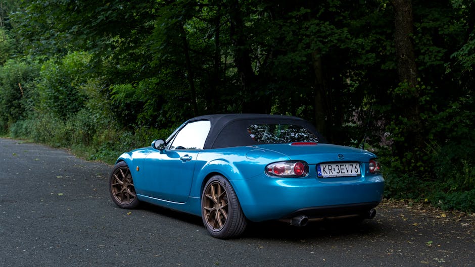Blue convertible car on a road through trees representing the financial journey