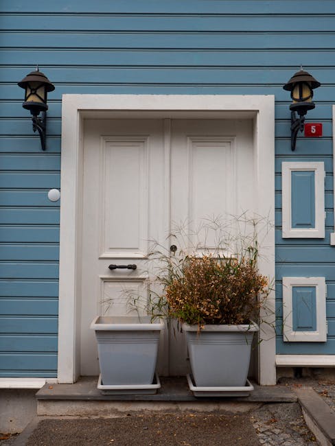 White front door of a blue house with number five representing accessibility and hospitality
